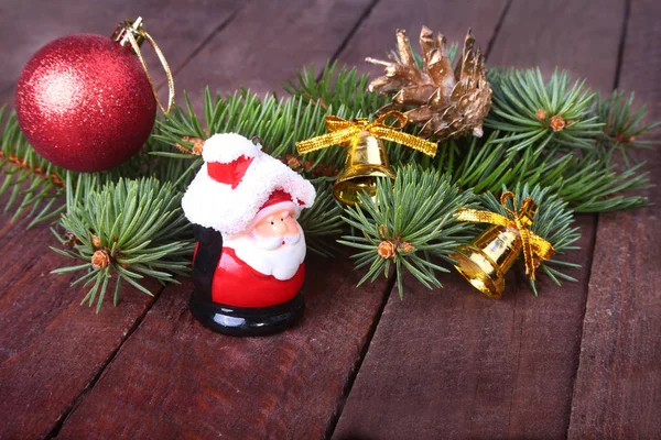 Weihnachtsdekoration mit schönen bunten Kugeln, Christbaum, Tannenzapfen und Weihnachtsmann auf Holzgrund — Stockfoto