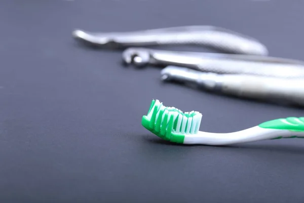 Cepillo dental con herramientas de dentista sobre fondo negro . — Foto de Stock