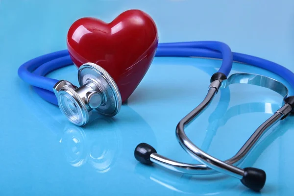 Stetoscopio medico e cuore rosso isolato su sfondo specchio . — Foto Stock
