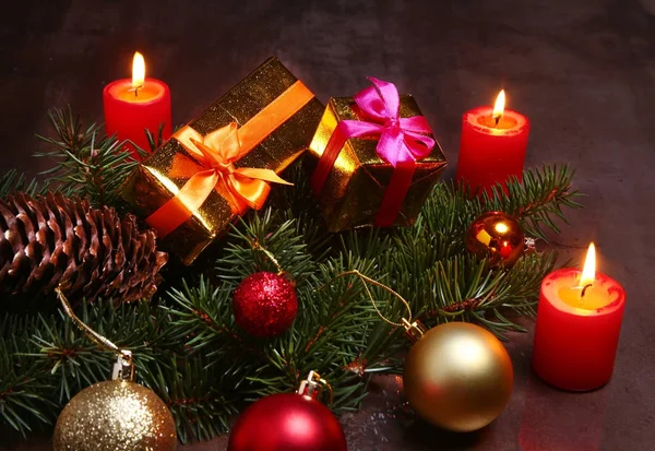 De decoratie van Kerstmis met rode kaarsen, kerstboom, geschenkdozen en kleurrijke ballen. Selectieve aandacht. — Stockfoto