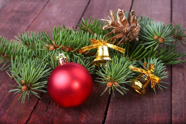 Рождественское украшение с красивыми красочными шарами, елкой и елочными шишками на деревянном фоне . — стоковое фото