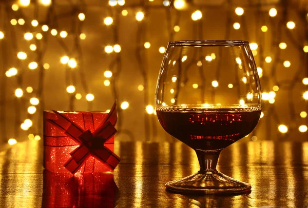 Whisky, Cognac, Brandy und Geschenkbox auf Holztisch. Festkomposition auf hellem Hintergrund. — Stockfoto