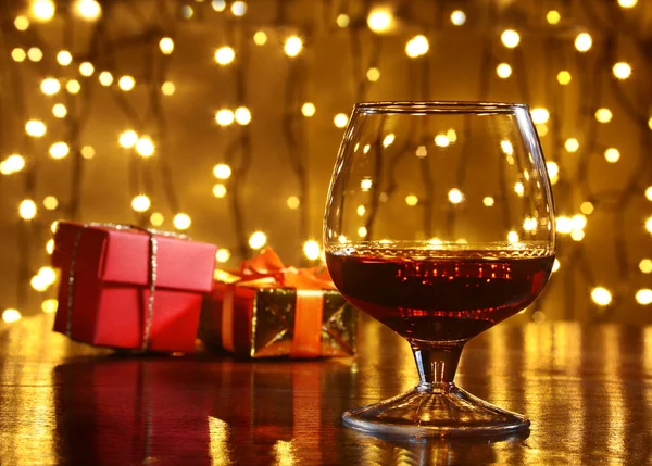 Whisky, Cognac, Brandy und Geschenkbox auf Holztisch. Festkomposition auf hellem Hintergrund. — Stockfoto