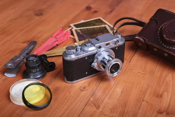 Alte Fotokamera, Ledertasche und anderes Fotozubehör auf Holzgrund. — Stockfoto