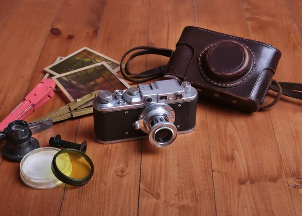 Alte Fotokamera, Ledertasche und anderes Fotozubehör auf Holzgrund. — Stockfoto