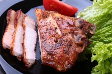 ızgara domuz pirzola ile domates, marul ve ketçap plaka üzerinde bırakır.