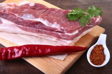 Çiğ domuz eti baharat ile kişniş ahşap kesme tahtası üzerinde bırakır. Hazır yemek pişirmek için.