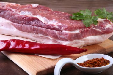 Çiğ domuz eti baharat ile kişniş ahşap kesme tahtası üzerinde bırakır. Hazır yemek pişirmek için.