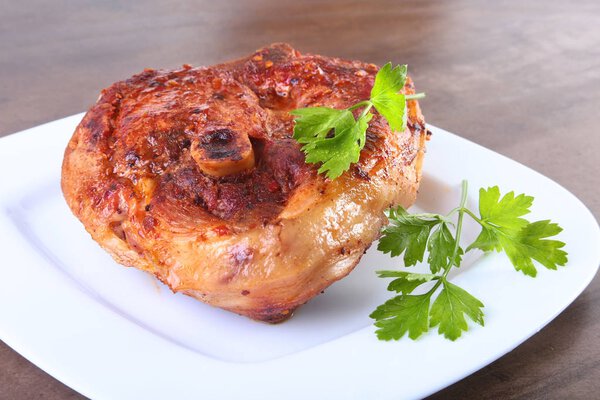 grilled pork chop with sauce on wooden table.