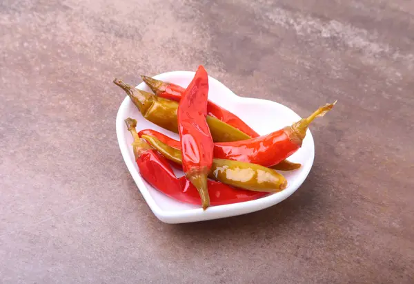 Skål med picklad röd hoade Chilipeppar på trä bakgrund. — Stockfoto