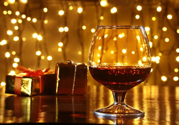 Whisky, Cognac, Brandy und Geschenkbox auf Holztisch. Festkomposition auf hellem Hintergrund. — Stockfoto