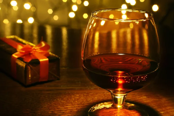Whiskey, cognac, brandy and gift box on wooden table. Celebration composition on the light background. — Stock Photo, Image