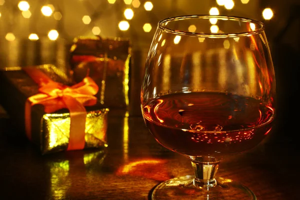 Whisky, Cognac, Brandy und Geschenkbox auf Holztisch. Festkomposition auf hellem Hintergrund. — Stockfoto