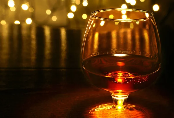 Whiskey, cognac, brandewijn en cadeau doos op houten tafel. Samenstelling van de viering op de lichte achtergrond. — Stockfoto