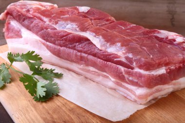 Çiğ domuz eti baharat ile kişniş ahşap kesme tahtası üzerinde bırakır. Hazır yemek pişirmek için.