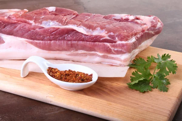 Raw pork meat with spices Leaves of coriander on wooden cutting board. Ready for cooking. — Stock Photo, Image