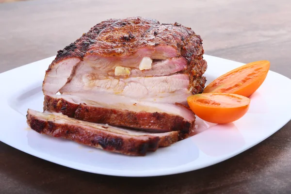 Жареная свиная отбивная с помидорами и кетчупом на тарелке . — стоковое фото