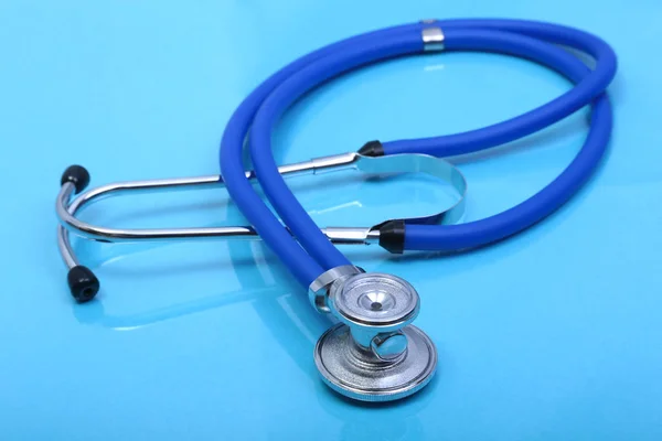 Stéthoscope et équipement médicalsur fond bleu — Photo