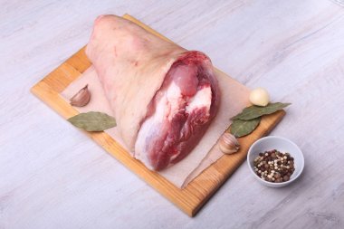 Çiğ domuz knuckle, aromatik defne yaprağı, sarımsak ve baharat bir kesme tahtası üzerinde kurumuş. Seçici odak. Hazır yemek pişirmek için.