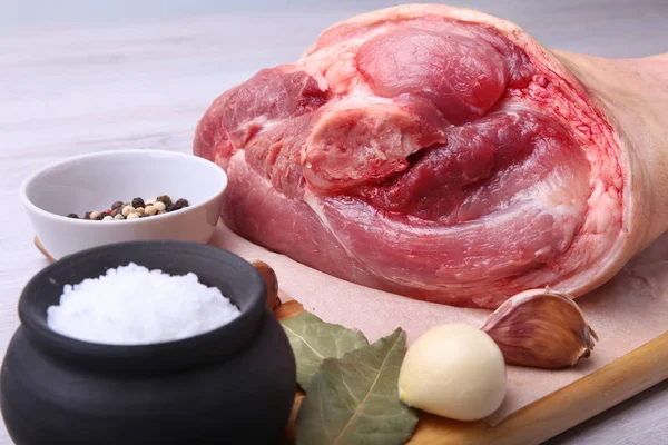 Raw pork knuckle, Aromatic dried bay leaves, garlic, sea salt and spices on a cutting board. Selective focus. Ready for cooking. — Stock Photo, Image