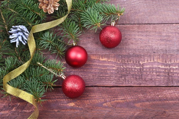 Рождественское украшение с красивыми красочными шарами, елкой и лентами на деревянном фоне . — стоковое фото
