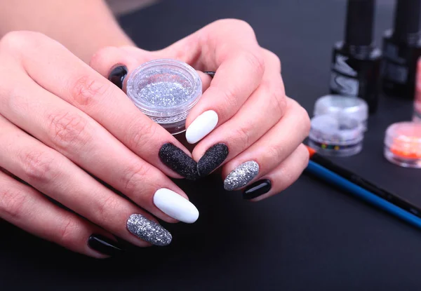 Manicura de uñas blancas y negras. Estilo de vacaciones brillante Manicura con destellos. Botella de esmalte de uñas. Manos de belleza. Clavos con estilo, esmalte de uñas —  Fotos de Stock