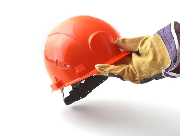 Pracovníka v ochranné rukavice oranžová čepice drží v ruce. Bezpečnostní přilba. — Stock fotografie