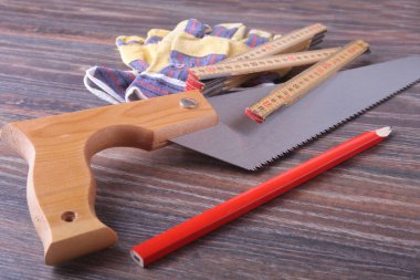 Turuncu kask, koruyucu gözlük, eldiven, testere ve ahşap arka plan kasette ölçme. metninizi yerleştirebilirsiniz