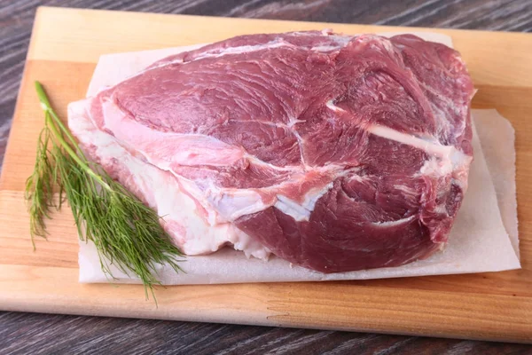 Raw pork steaks on wooden board with herbs, garlic and spices ready for cooking. Selective focus. — Stock Photo, Image