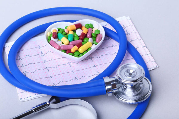 Стетоскоп, RX рецепт и красочные таблетки ассортимента и капсулы на тарелке
.