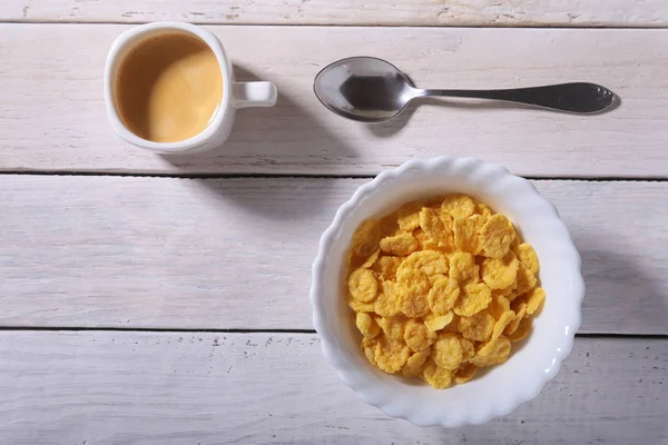 Καλαμπόκι νιφάδες δημητριακών σε ένα μπολ και καπάκι με καφέ espresso. Πρωινό το πρωί. — Φωτογραφία Αρχείου
