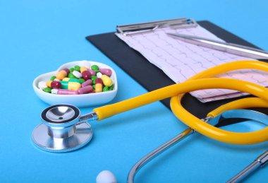 Stetoskop, Rx reçeteli ve renkli ürün yelpazesine hap ve kapsül plaka üzerinde.