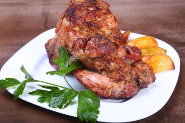 Beyaz bir tabak patates ile sulu domuz boyun eti ızgara.