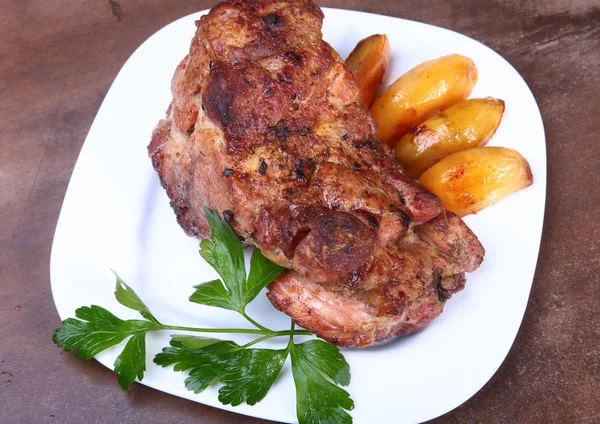 Succosa costolette di maiale sono alla griglia con patate su un piatto bianco . — Foto Stock