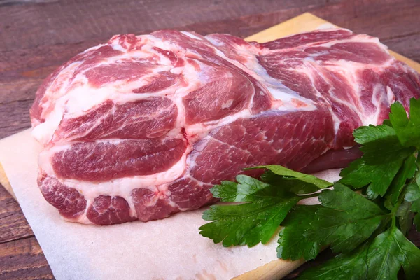 Carne cruda de chuleta de cerdo con hojas de perejil sobre un fondo de piedra. Listo para cocinar . —  Fotos de Stock