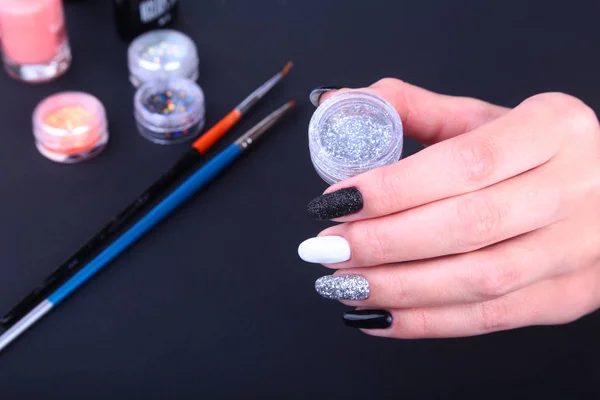 Manicura de uñas blancas y negras. Estilo de vacaciones brillante Manicura con destellos. Botella de esmalte de uñas. Manos de belleza. Clavos con estilo, esmalte de uñas — Foto de Stock