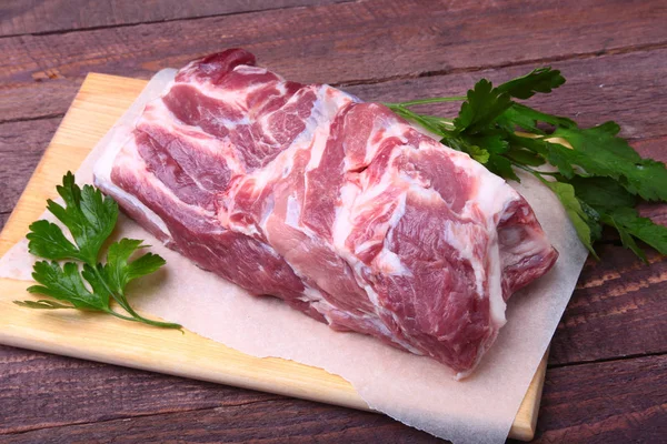 Carne cruda de chuleta de cerdo con hojas de perejil sobre un fondo de piedra. Listo para cocinar . — Foto de Stock