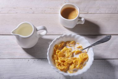 Mısır gevreği tahıl bir kase, süt ile cam ve espresso kahve kap. Sabah kahvaltı.