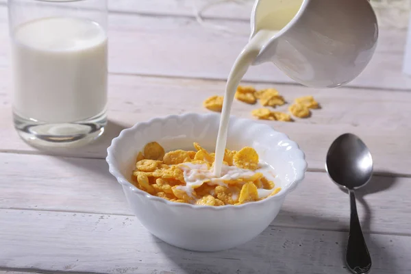 Γάλακτος έκχυση σε ένα μπολ με πεντανόστιμο καλαμπόκι νιφάδα δημητριακών και καπάκι με καφέ espresso. Πρωινό το πρωί. — Φωτογραφία Αρχείου