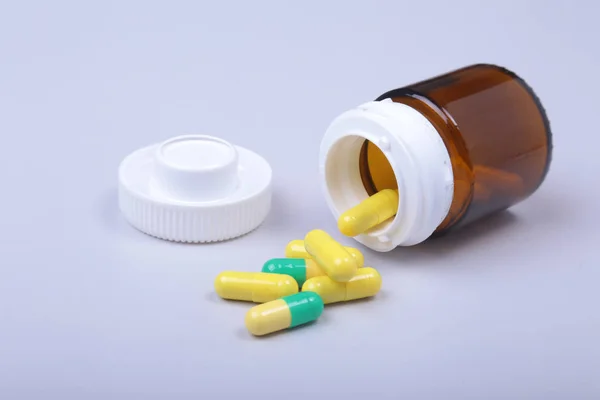 Coloridas pastillas y cápsulas médicas en la mesa blanca con espacio para el texto . — Foto de Stock