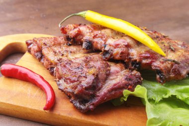 marul yaprakları, sıcak biber ve sos ahşap kesme tahtası üzerinde mangalda kaburga ızgara.