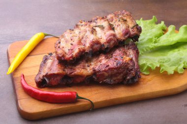 marul yaprakları, sıcak biber ve sos ahşap kesme tahtası üzerinde mangalda kaburga ızgara.