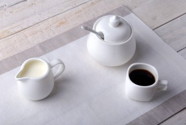 Bir fincan sıcak kahve espresso, kahve çekirdekleri, sürahi süt ve şeker kopya alanı için beyaz arka plan üzerine bir kase. Kahve kavramı.