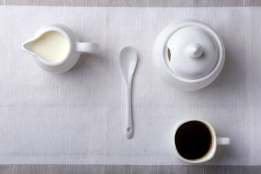 Bir fincan sıcak kahve espresso, kahve çekirdekleri, sürahi süt ve şeker kopya alanı için beyaz arka plan üzerine bir kase. Kahve kavramı.