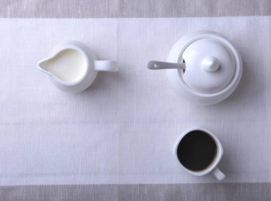 Bir fincan sıcak kahve espresso, kahve çekirdekleri, sürahi süt ve şeker kopya alanı için beyaz arka plan üzerine bir kase. Kahve kavramı.