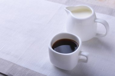 Bir fincan sıcak kahve espresso, kahve çekirdekleri, sürahi süt ve şeker kopya alanı için beyaz arka plan üzerine bir kase. Kahve kavramı.