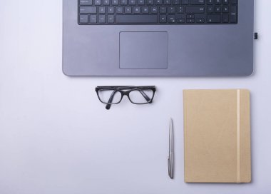 Rahat çalışma close-up yerleştirin ofis dizüstü bilgisayar, dizüstü bilgisayar, gözlük, kalem ve tablo kopya alanı ile döşeme diğer ekipmanlar. Üstten Görünüm.
