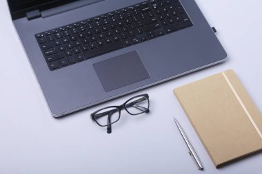 Rahat çalışma close-up yerleştirin ofis dizüstü bilgisayar, dizüstü bilgisayar, gözlük, kalem ve tablo kopya alanı ile döşeme diğer ekipmanlar.