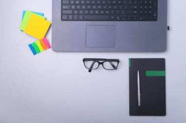 Rahat çalışma close-up yerleştirin ofis dizüstü bilgisayar, dizüstü bilgisayar, gözlük, kalem ve tablo kopya alanı ile döşeme diğer ekipmanlar. Üstten Görünüm.