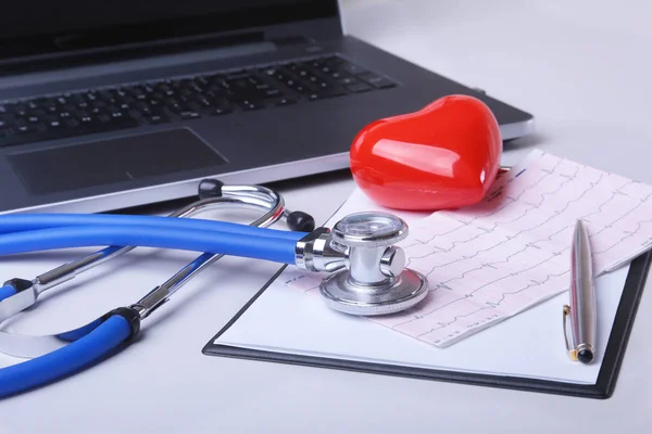 Lugar de trabajo del médico con portátil, estetoscopio, prescripción RX, gafas y corazón rojo y portátil en la mesa blanca. Vista superior. Copiar espacio . — Foto de Stock